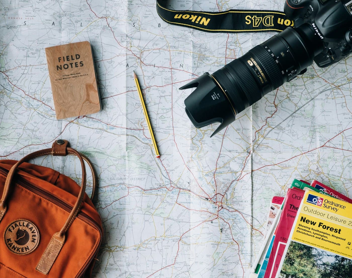 A map, notebook and camera laid out for trip planning